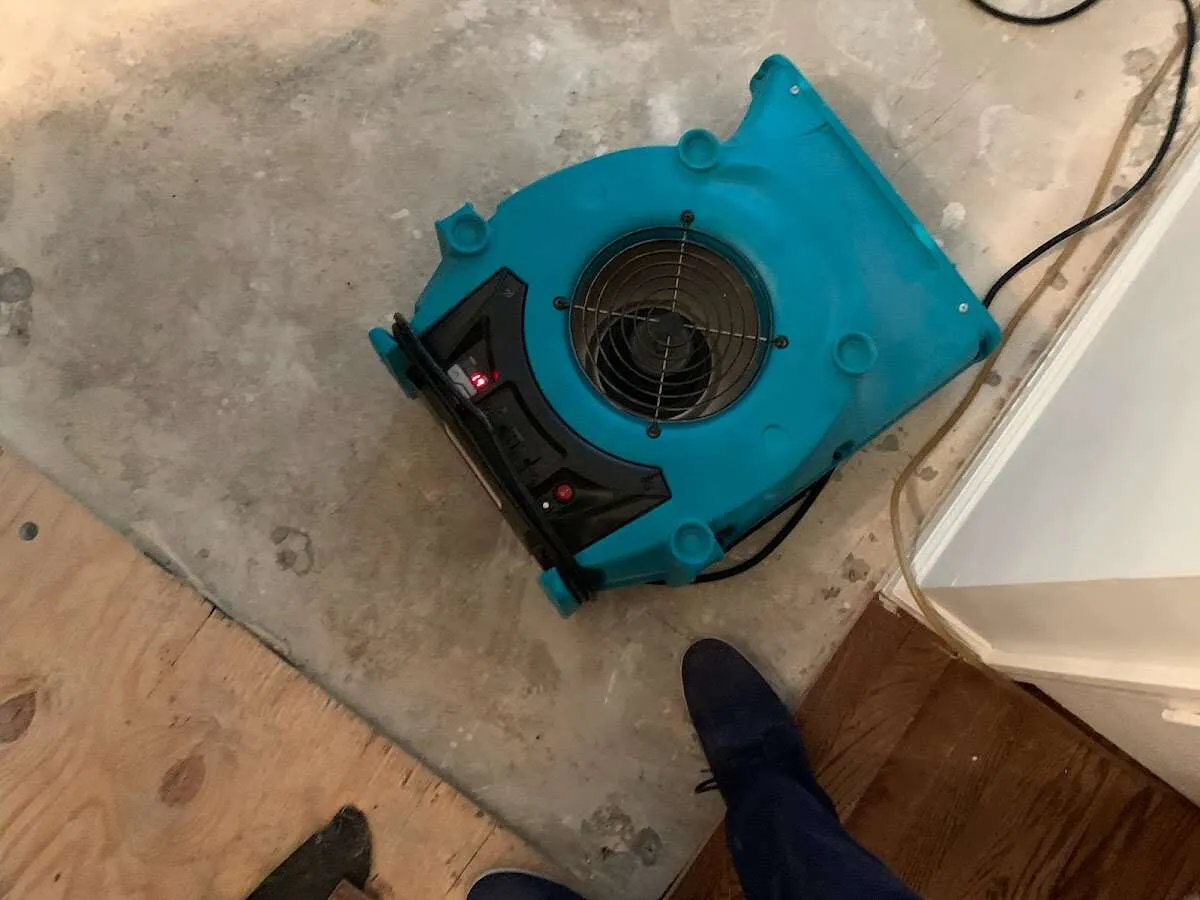 Air mover drying subfloor during Commercial Water Damage Restoration in Centerville